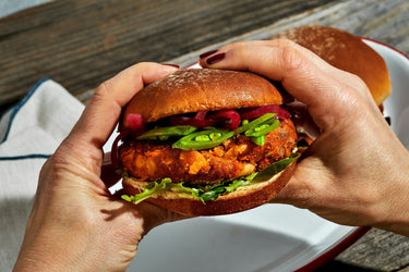Crispy White Bean & Sweet Potato Veggie Burger held in hands