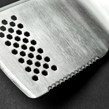 A closeup of the end of a HexClad spatula. There are many small holes on the end of the spatula.