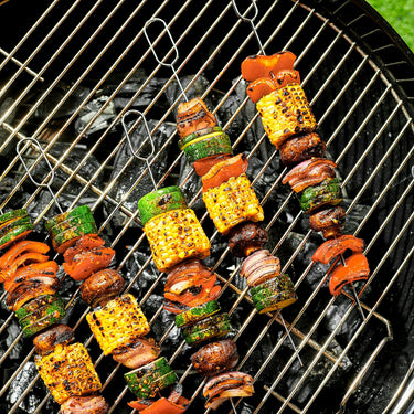 Many kebab skewers being barbecued on a grill.
