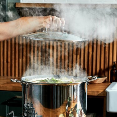 Frying pan with glass lid on gas stovetop