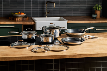 A set of HexClad pots and pans with lids on top of a kitchen counter.