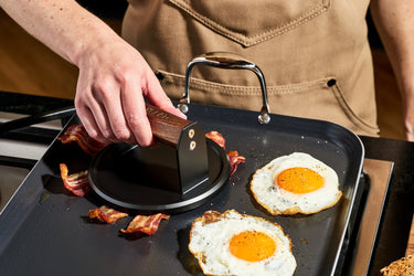 HexClad Burger Press pressing on bacon on HexClad
