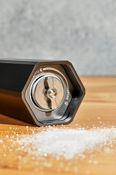 heavy duty HexClad HexMill salt grinder eith salt on wood surface around it 