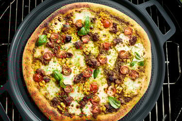 Grilled Corn, Tomato, & Italian Sausage Pizza on pizza steel on top of grill plate