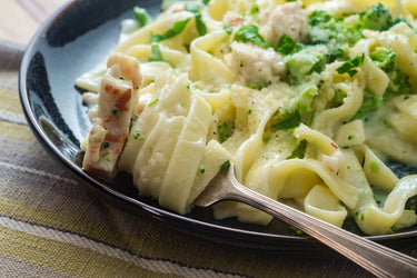 Fettuccine Alfredo with broccoli on black plate
