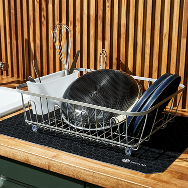 Dishes on a drying rack on top of a HexClad Dish Drying Mat.