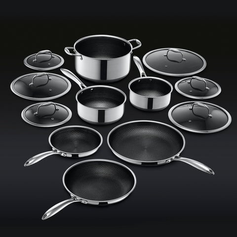 Set of stainless steel cookware with lids on a black background.