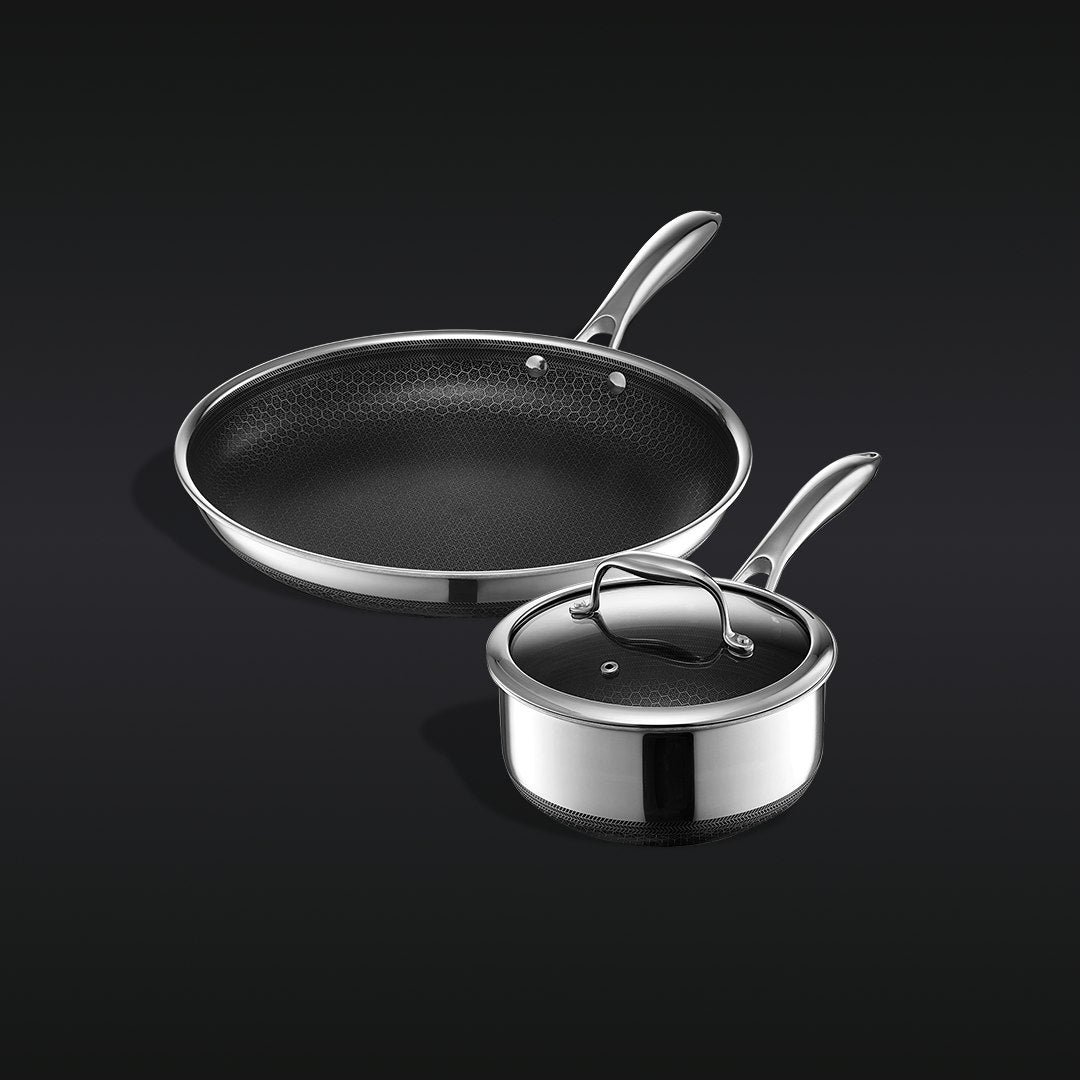 A nonstick frying pan and saucepan with a lid, featuring a hexagonal-patterned interior, on a black background.