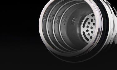 Close-up of a black metal top of the hexclad cocktail shaker with visible branding on a black background