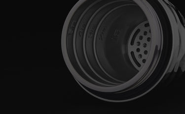 Close-up of a black metal top of the hexclad cocktail shaker with visible branding on a black background