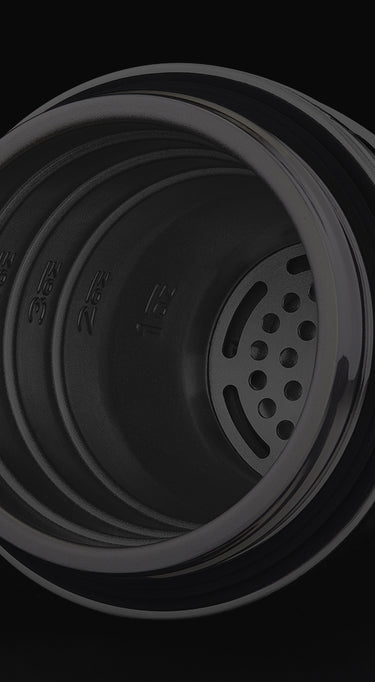 Close-up of a black metal top of the hexclad cocktail shaker with visible branding on a black background