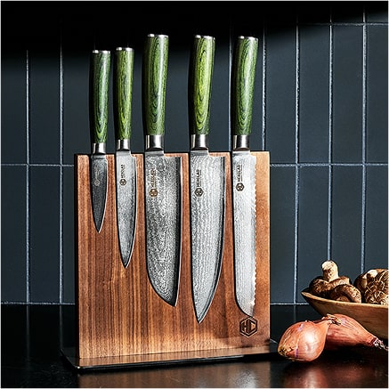 Set of five knives in a wooden block on a kitchen counter.