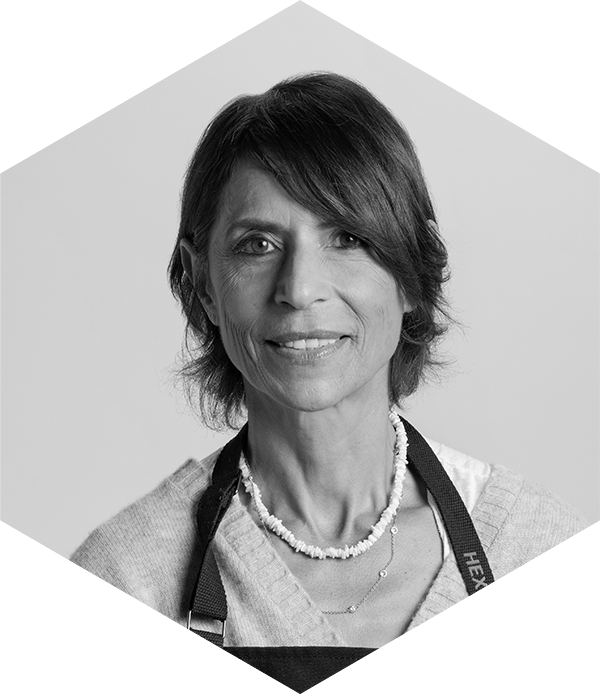 Portrait of a smiling woman with a necklace and apron.