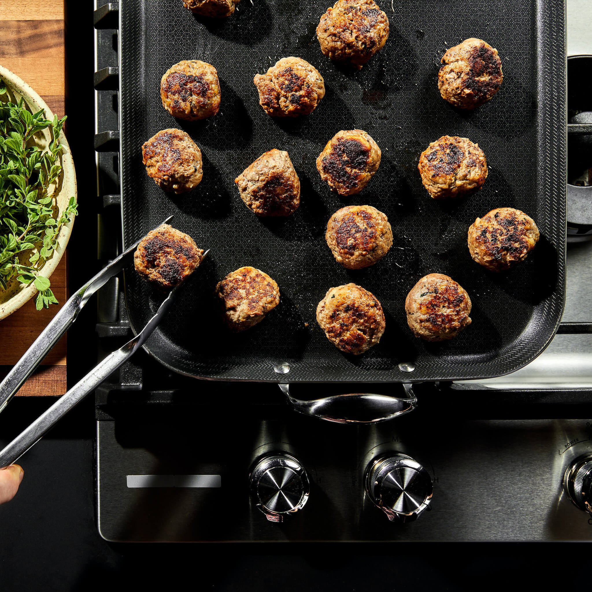 Deliciously seared meatballs on our Hybrid Double-Burner Griddle - the only tri-ply, hybrid griddle in the market. Perfect for large gatherings and meal prep with its consistent heating and superior browning capabilities.