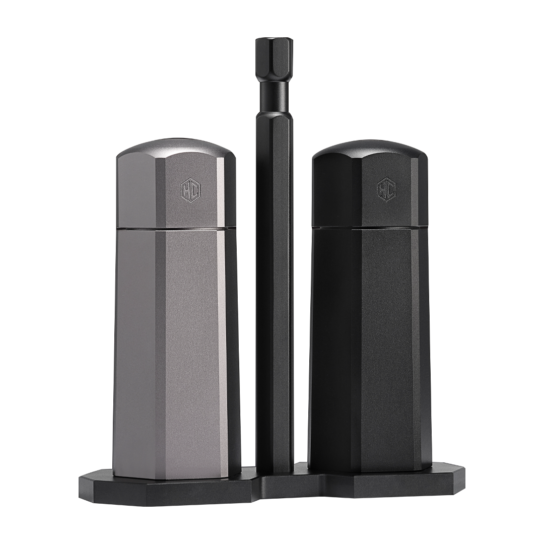 HexClad salt and pepper grinder set on a stand with a sleek design, featuring one grinder in stainless steel finish and another in matte black.