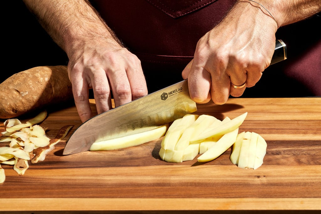 Hands and knife cutting potato