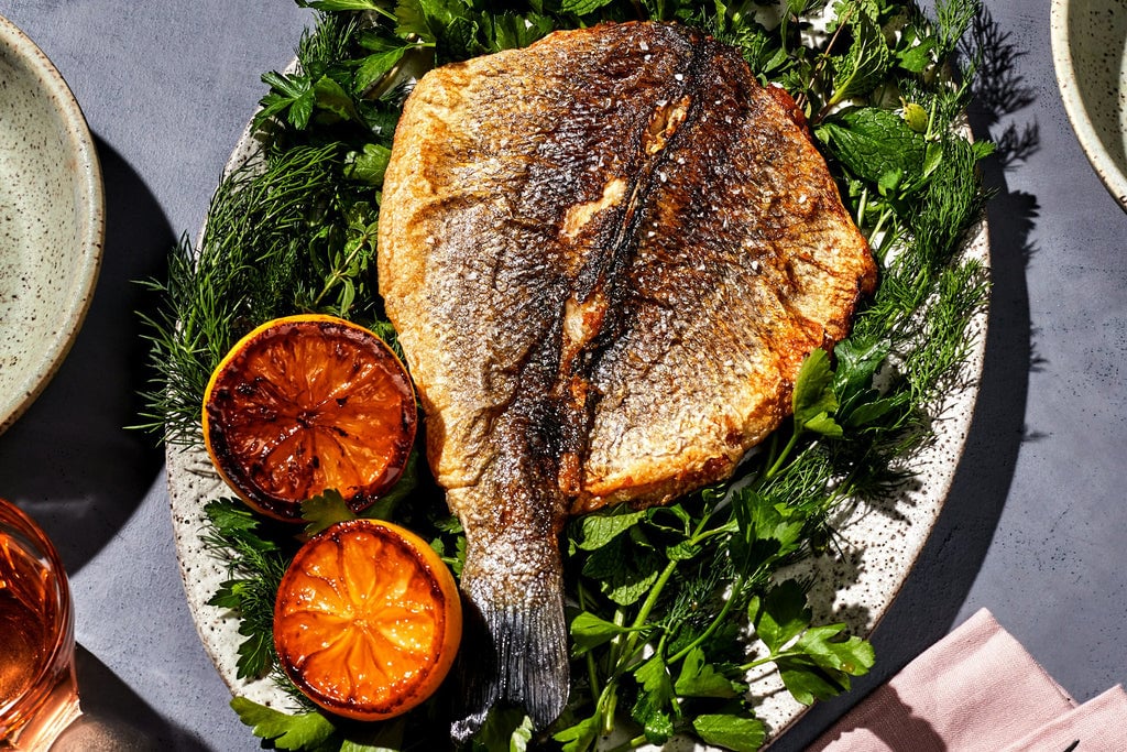 Whole Branzino on a plate of greens