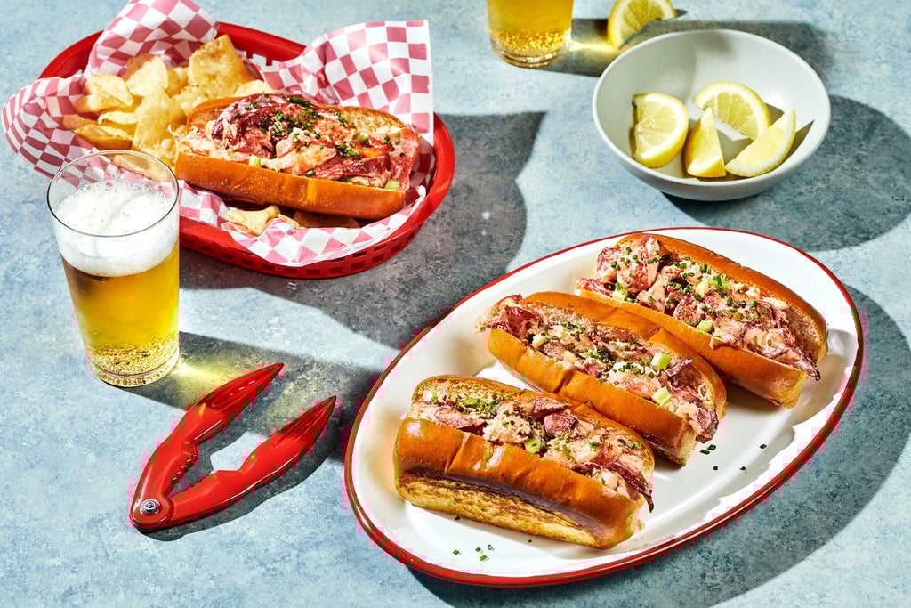 Lobster Rolls on a plate next to beer