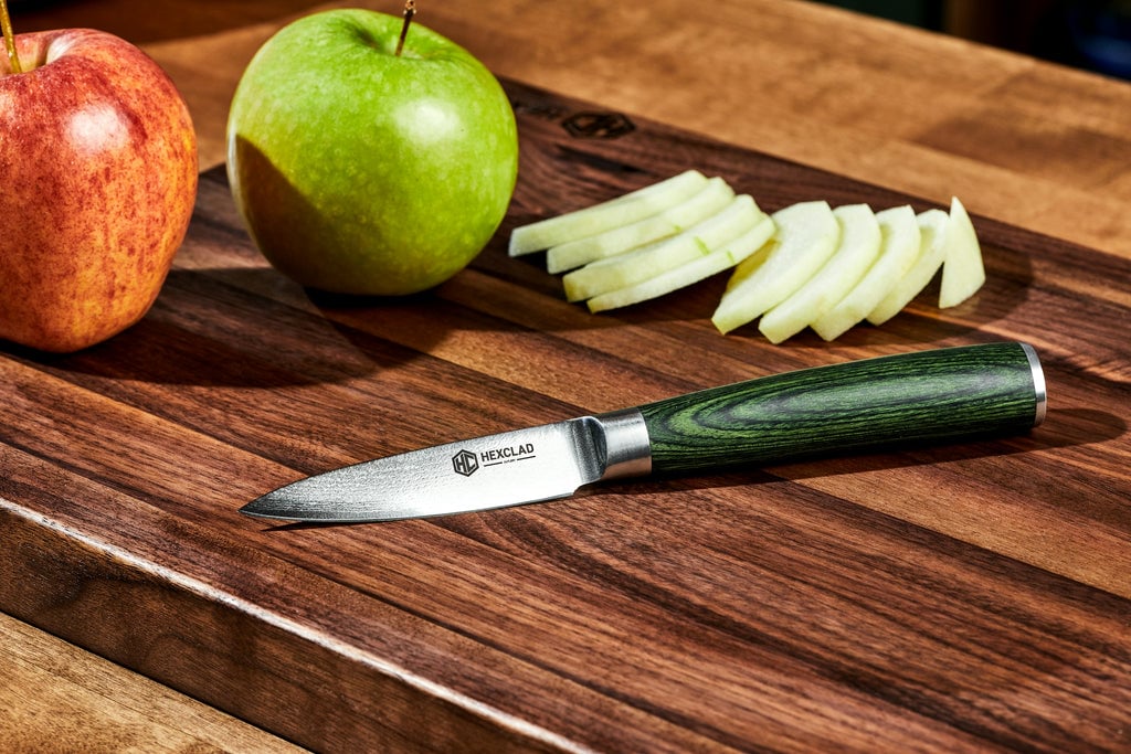 Sliced apples on cutting board next to pairing knife