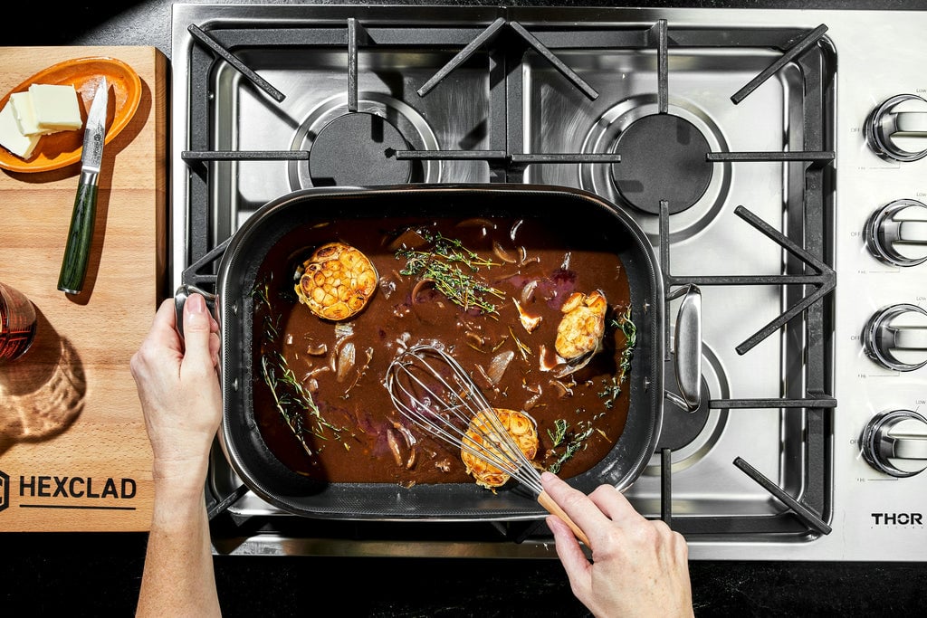 Gravy being stirred in a small roasting pan