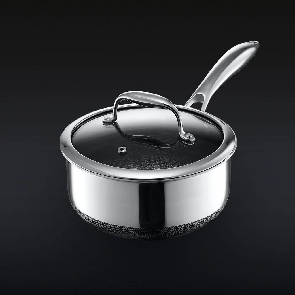 Stainless steel saucepan with a glass lid on a dark background.