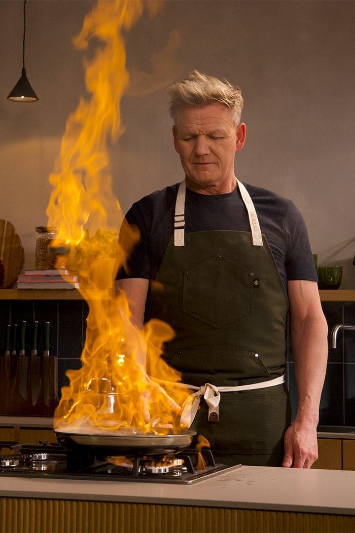 Chef cooking with a large flame in a kitchen.
