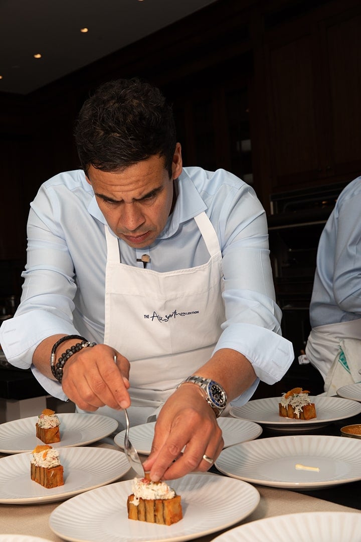 Chef preparing dessert plates with precise presentation.