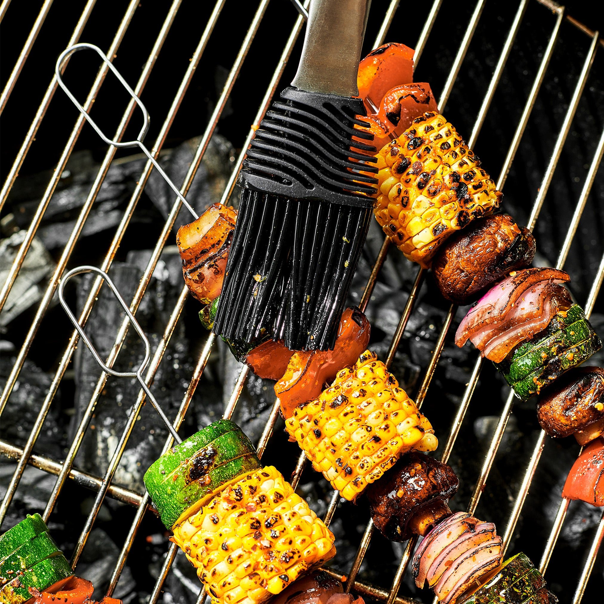 Vegetable skewers with corn, zucchini, mushrooms, and bell peppers on a grill pan.