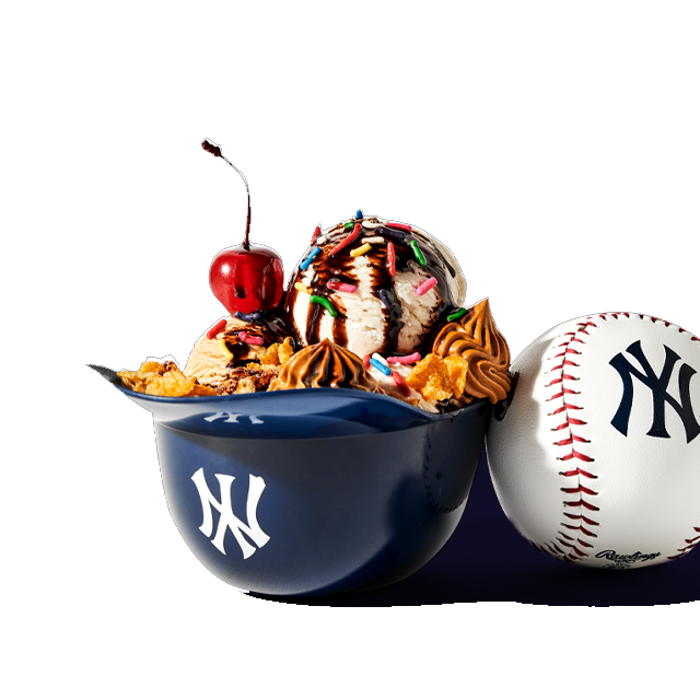 Baseball-themed ice cream sundae with sprinkles and cherry in a cap-shaped bowl.