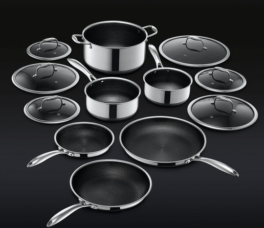 A set of shiny silver stainless steel cookware with lids displayed on a dark background.